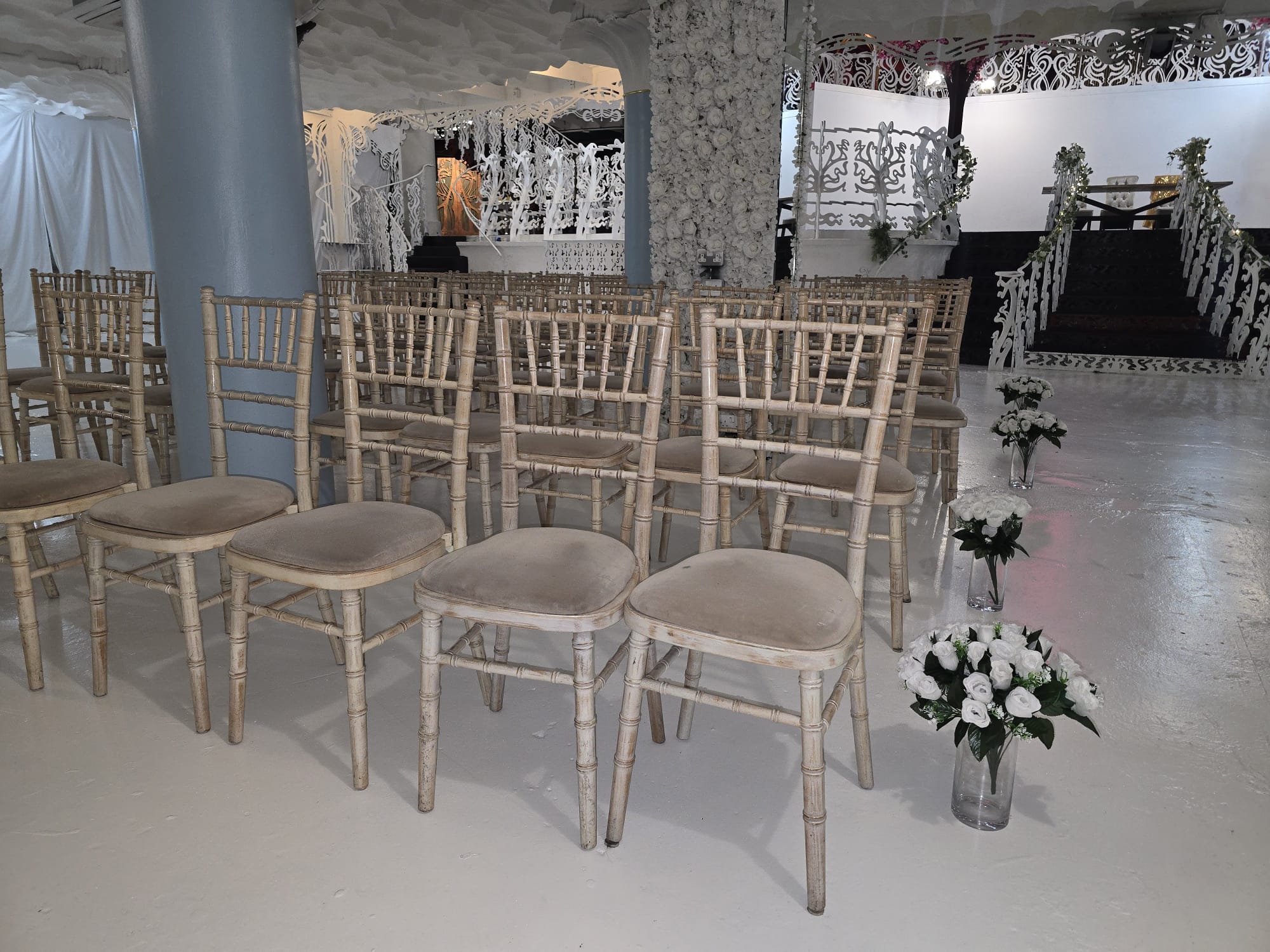 Rows of limewash Chiavari chairs with white rose aisle bouquets facing the Nikah stage at Opulent @ 35 Liverpool
