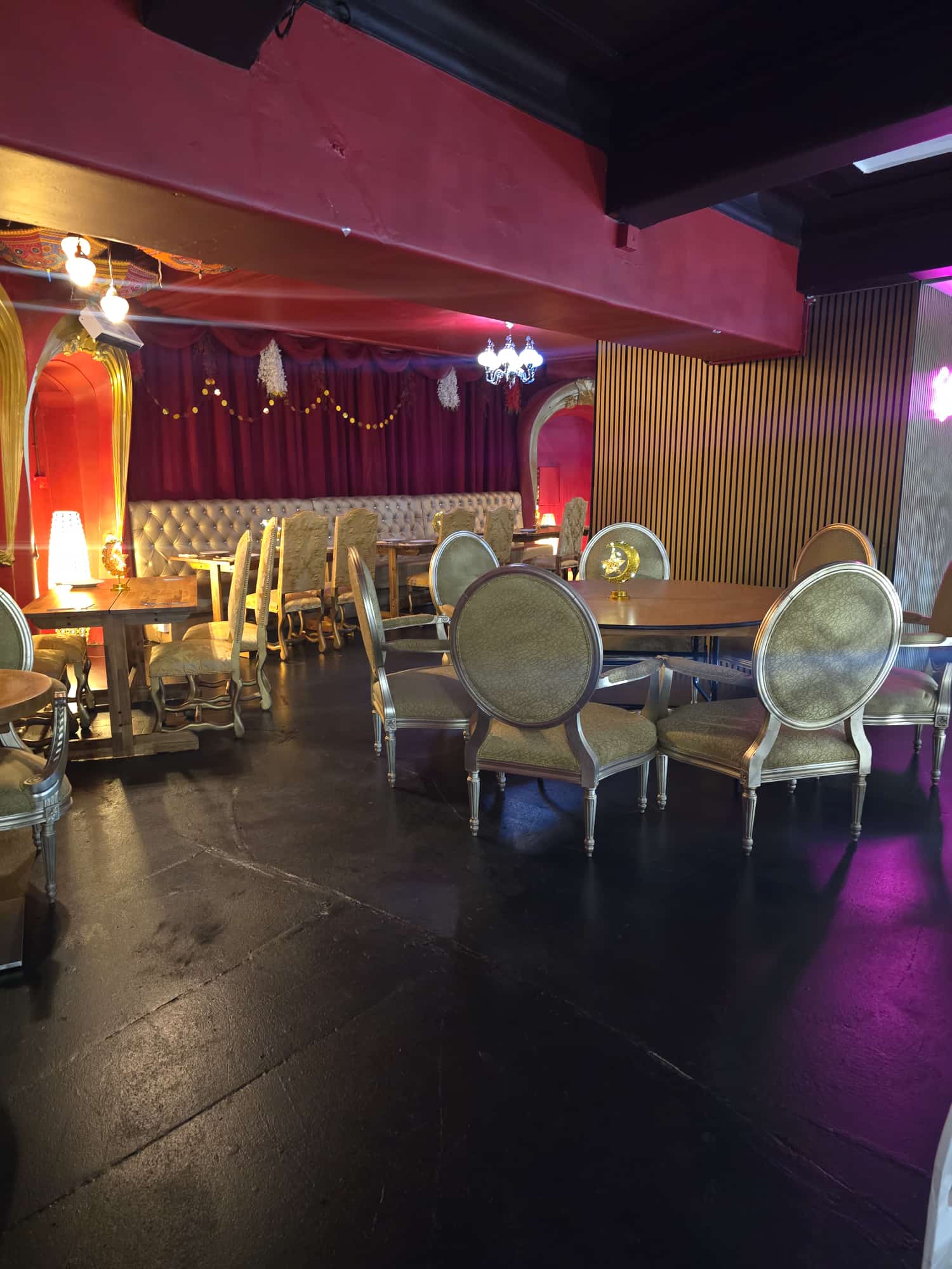 Fozia's restaurant dining room at Opulent @ 35 Liverpool — red velvet walls, gold chandeliers, tufted banquet seating and carved chairs