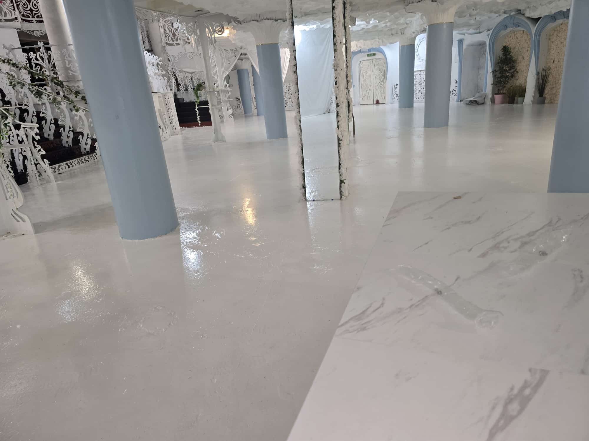 Empty white ballroom at Opulent @ 35 Liverpool with mirrored columns, pale blue Art Nouveau pillars and polished marble floor before styling