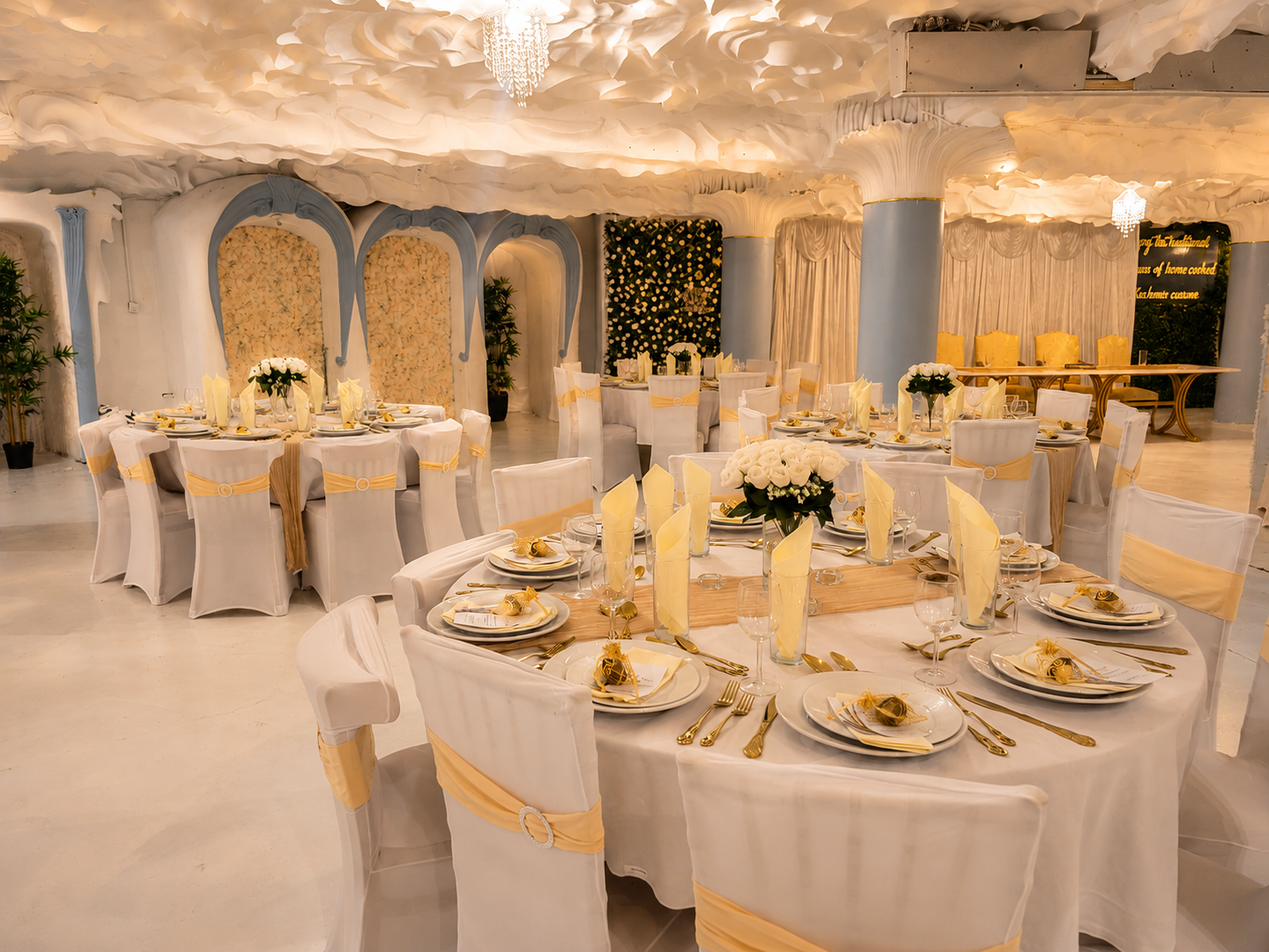Wide view of the Opulent @ 35 ballroom dressed for a wedding with gold drapery and white roses in Liverpool
